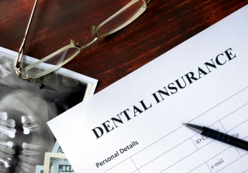 Dental insurance paperwork on dark wood table