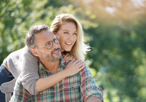 Man and woman hugging outdoors on sunny day