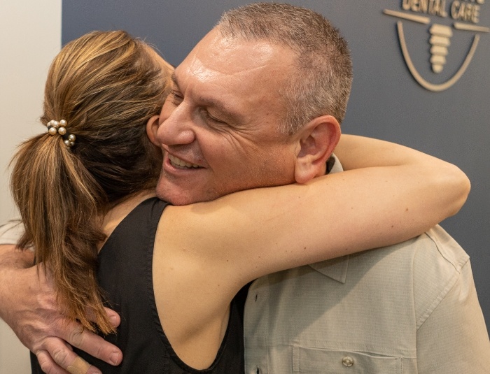 Close up of man and woman hugging in Phoenix dental office