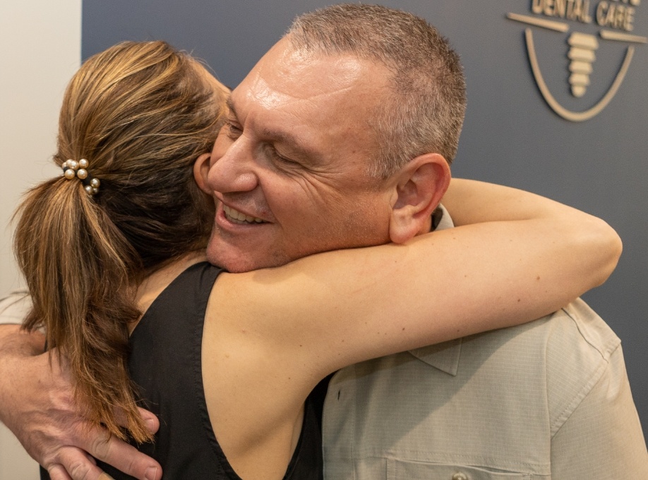 Close up of man hugging woman in dental office