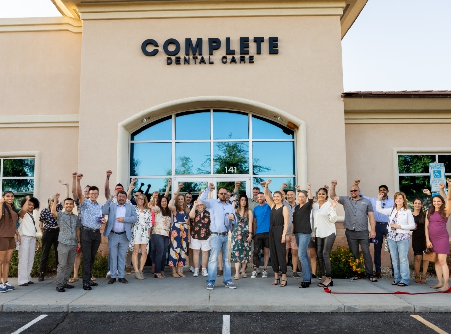Group of people fist pumping after ribbon cutting at Complete Dental Care