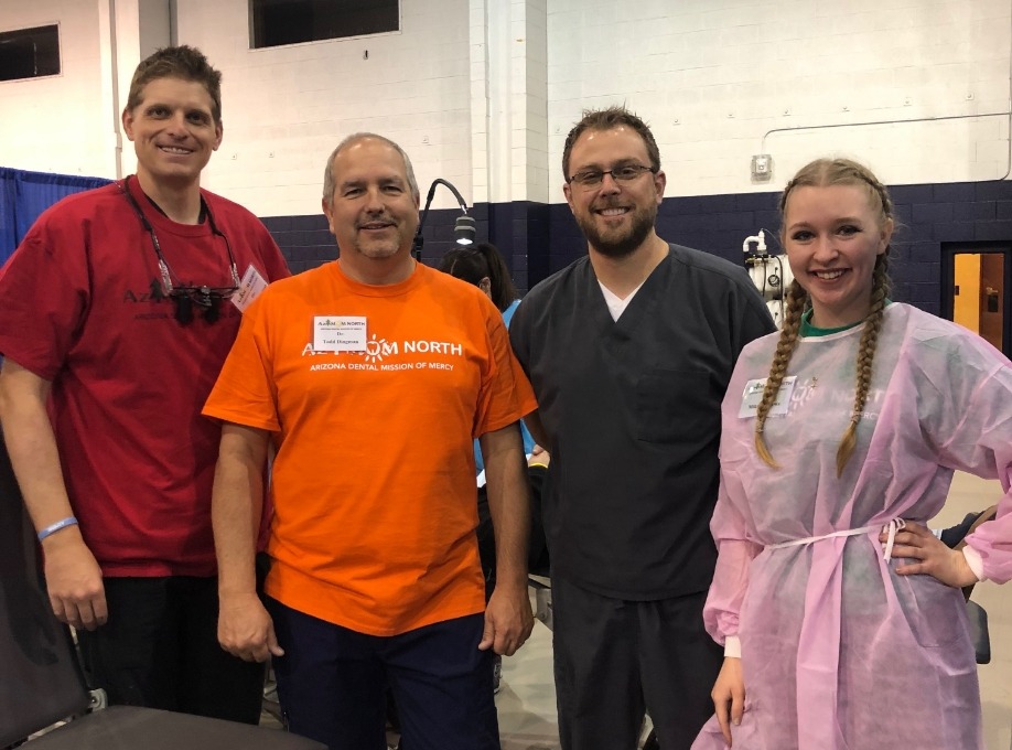 Doctor Rodda with three volunteers at community event in a gym