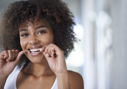 Woman smiling while flossing her teeth