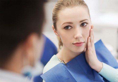 Woman with toothache talking to dentist