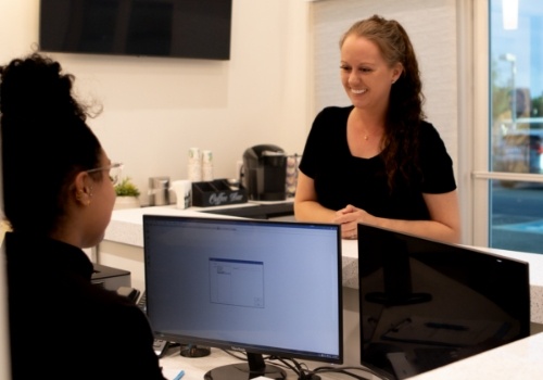 Dental patient talking to dental team member at front desk