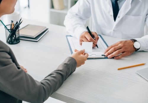 Dental patient handing payment card to dentist