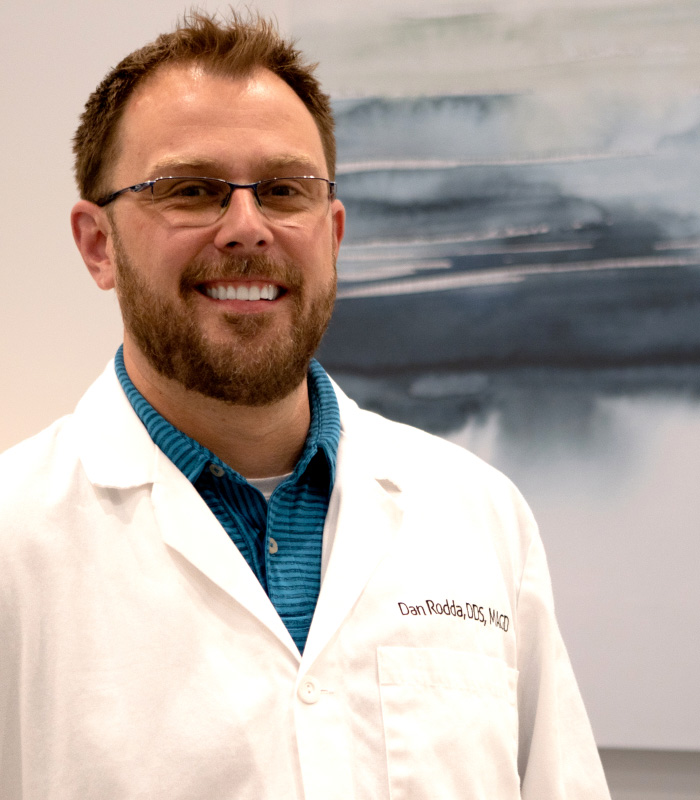Phoenix dentist Doctor Dan Rodda smiling in a white lab coat