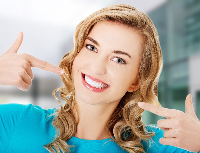 a patient pointing to her cosmetic dental results