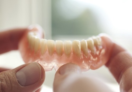 Person holding a full denture in their hands