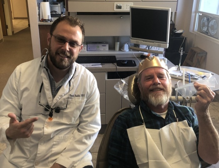 Doctor Rodda with dental patient holding plastic bag with old dental work