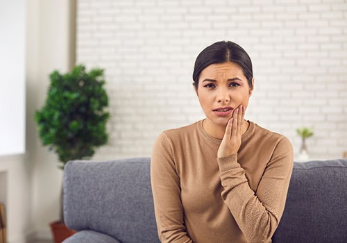Woman sitting on couch with toothache