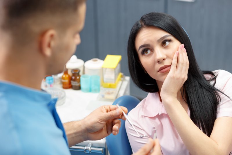 A woman in pain at her emergency dentist