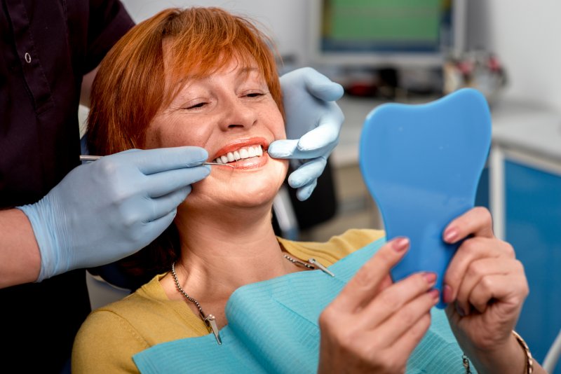 An older woman correcting her ill-fitting dentures