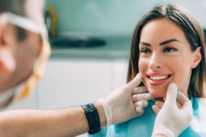 Young woman smiling being examined by dentist.
