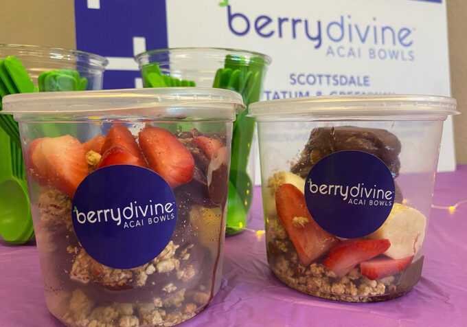 Two Berry Divine Acai Bowls with fruit and yogurt are placed on a table, showcasing a colorful and healthy snack option.